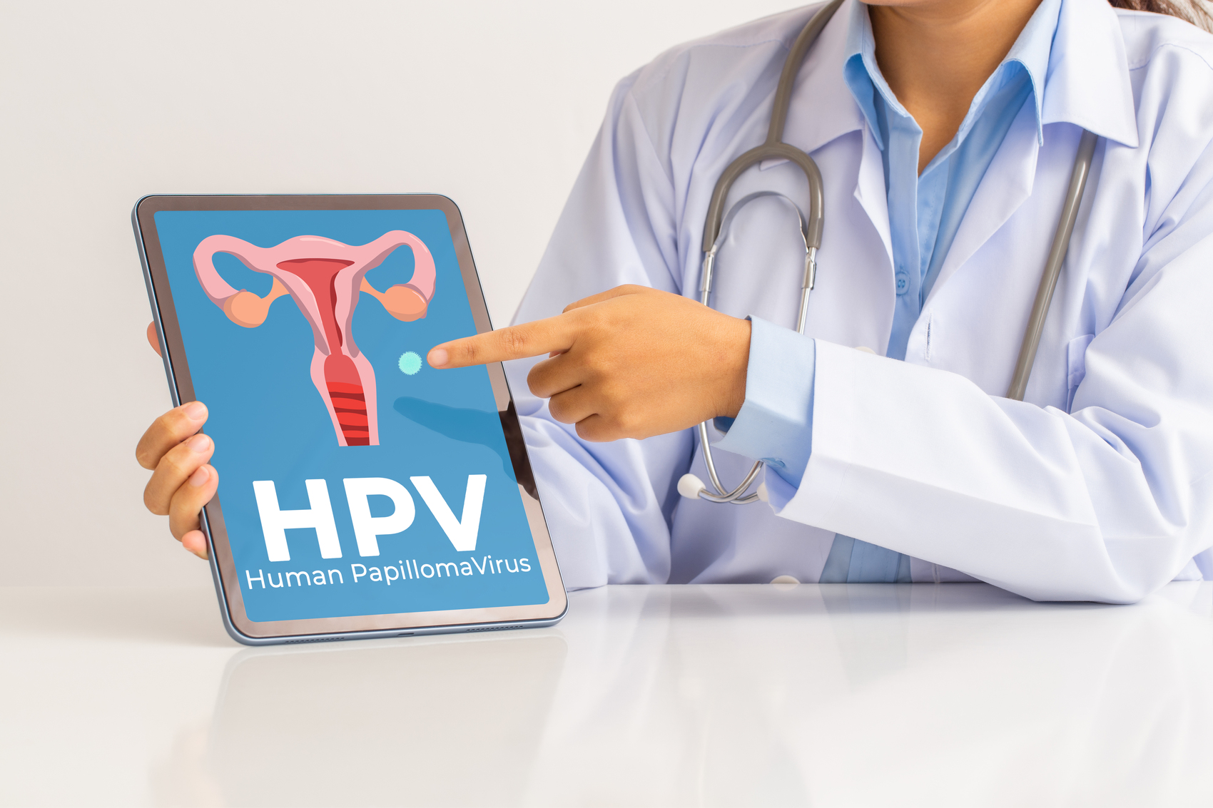 HPV(人类乳头瘤病毒)女医生讲解知识，并在平板屏幕上指出女性健康问题，一些病毒株感染生殖器，可导致宫颈癌。.jpg